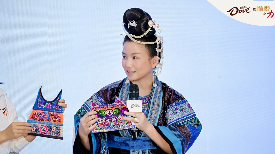杨双芝现场展示她的苗绣作品，她希望带动身边的人改善生活，并把非遗苗绣传承下去.jpg